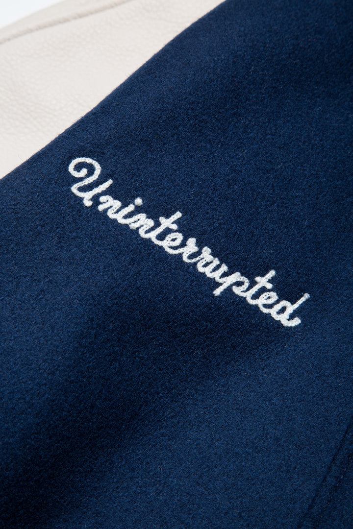 UNINTERRUPTED X GOLDEN BEAR ALL STAR VARSITY JACKET BLUE (4458685235280) - close up of the "uninterrupted" embroidery